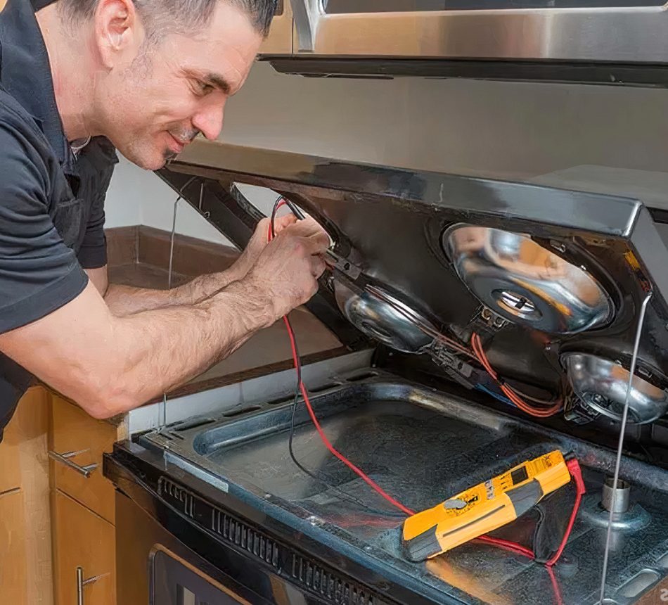 Technician testing the burner assembly of a range with a multimeter