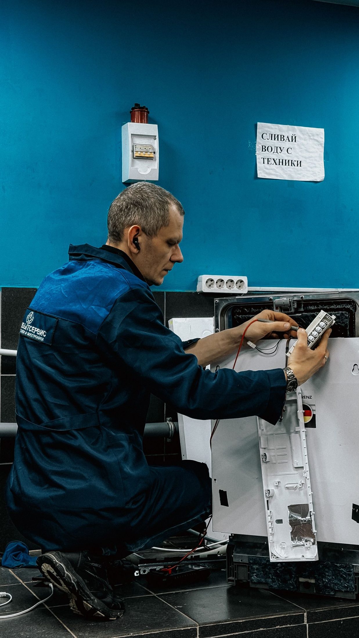 Technician in uniform repairing a home appliance