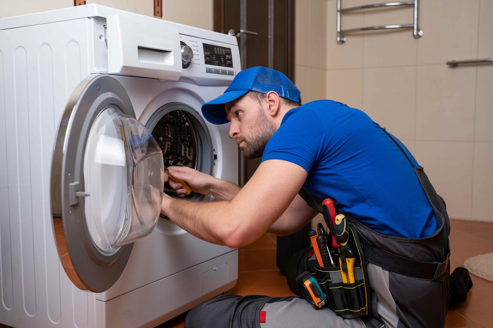 Technician adjusting the door assembly of a front load washing machine